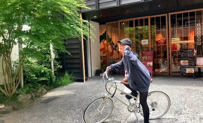 インバウンドリーグの前でレンタサイクルに乗る旅行者
