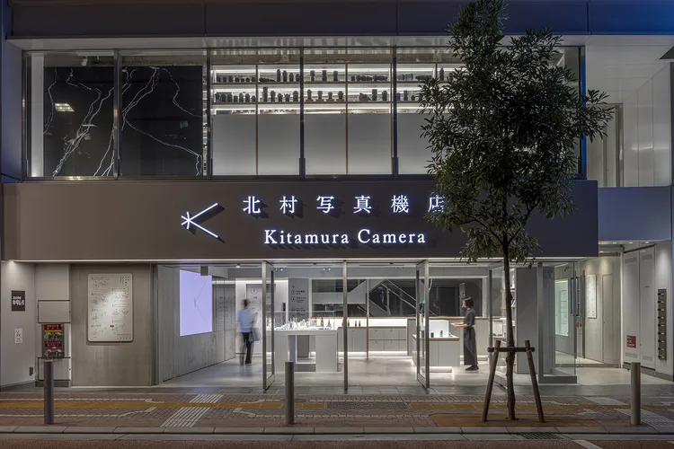 夜の北村写真機店のモダンなガラス張り店舗