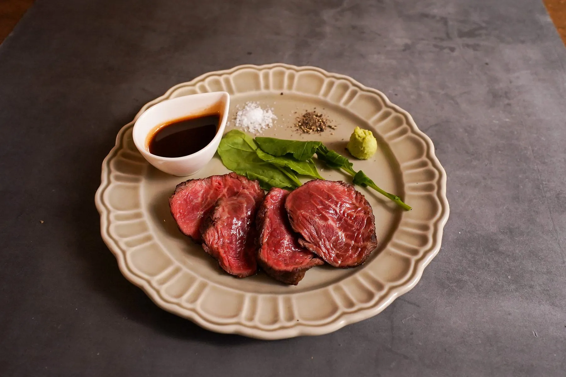 近江牛のステーキ。塩・胡椒・わさびを添えた一皿