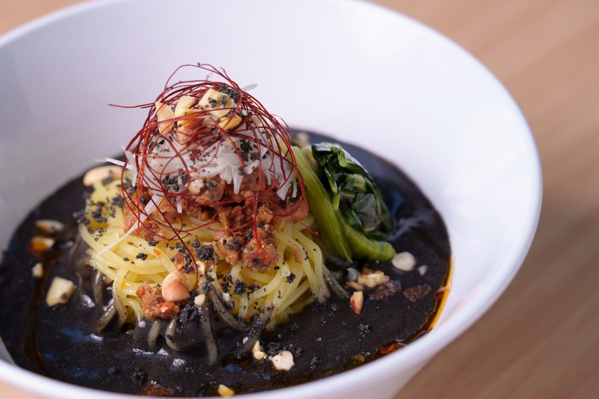 糸唐辛子をあしらった黒いソースの麺