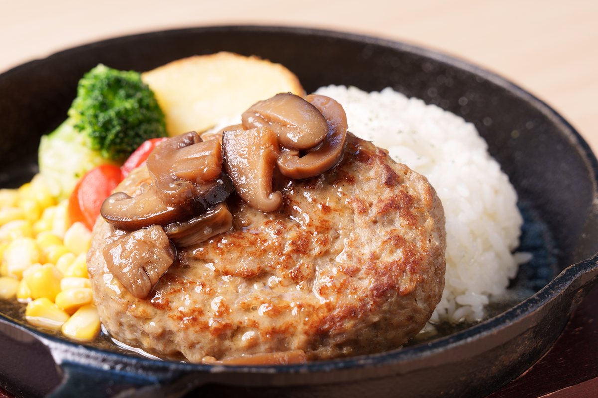鉄鍋で供されるハンバーグとライス