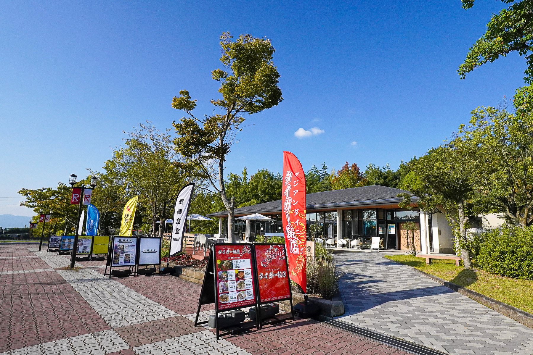 大きな屋根と芝生のテラス席がある外観