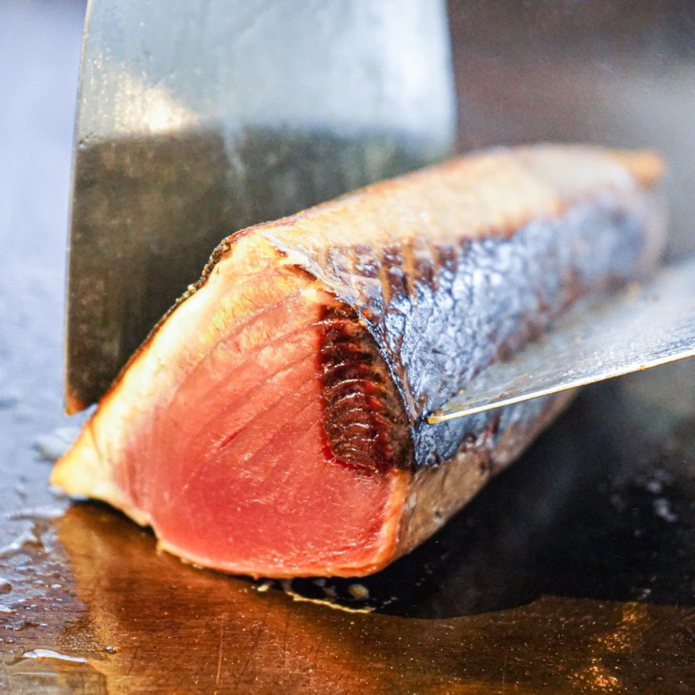 熱した鉄板で鰹の表面を焼いているところ
